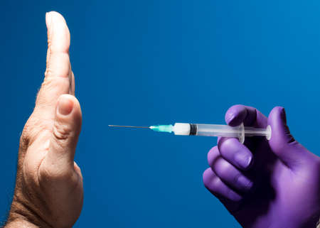 Man showing his palm refusing nurse injection or vaccination.の写真素材