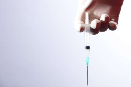 Doctor or nurse holding flu vaccine, syringe for measles injection preparations for baby and adult vaccination, medicine and drug concept, white backgroundの写真素材