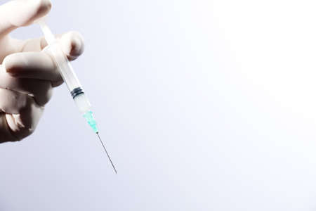 Doctor or nurse holding flu vaccine, syringe for measles injection preparations for baby and adult...