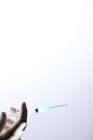 Doctor or nurse holding flu vaccine, syringe for measles injection preparations for baby and adult vaccination, medicine and drug concept, white backgroundの写真素材