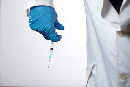 Doctor or nurse holding flu vaccine, syringe for measles injection preparations for baby and adult vaccination, medicine and drug concept, white backgroundの写真素材