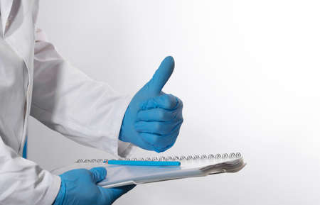 Doctor writes notes on hospital clipboard