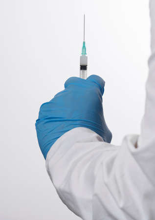 Doctor or nurse holding flu vaccine, syringe for measles injection preparations for baby and adult vaccination, medicine and drug concept, white backgroundの写真素材