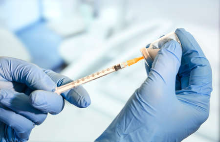 Doctor or nurse holding flu vaccine, measles injection syringe prepare for baby and adult...
