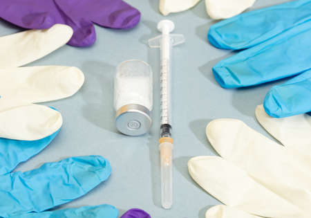 Vaccination and immunization concept syringe with ampoules, colored glovesの写真素材
