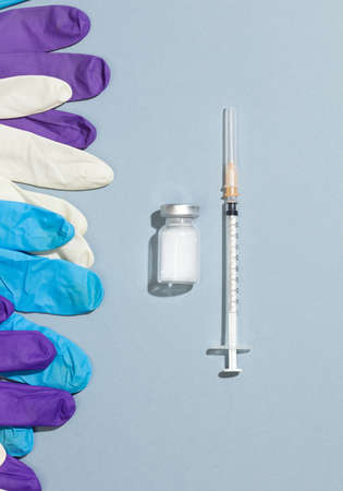 Vaccination and immunization concept syringe with ampoules, colored gloves