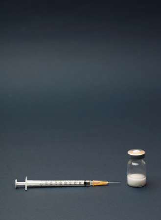 Syringe and ampules on gray background.Vaccination.