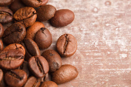 Close up view of roasted coffee beans, old wooden background