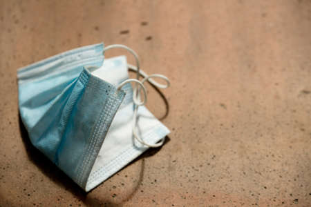 Medical protection mask lost on the ground was used. Disposable mask lying on the street. Incorrectly discarding the used face maskの写真素材