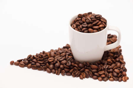 white ceramic cup, with coffee beans and white background