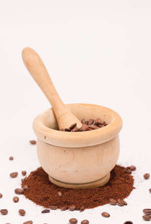 wooden bowl with mace (mortar), coffee beans and ground, white backgroundの写真素材