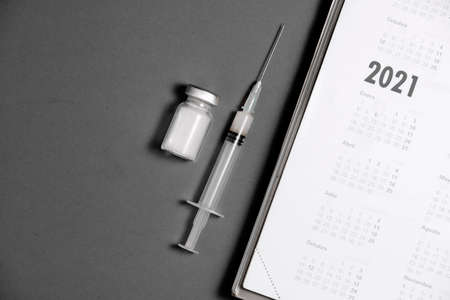 syringe and vaccine on calendar 2021 (black and white), black backgroundの写真素材