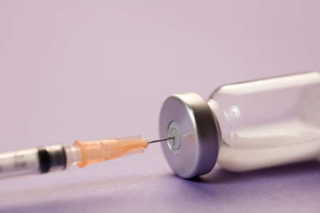 medical syringe cannula with vaccine vial, lilac background. macroの写真素材