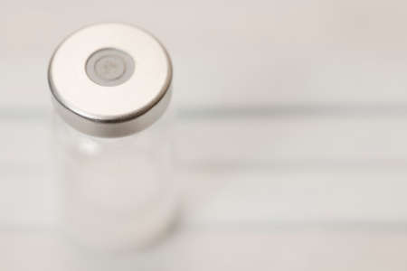 Vial of vaccine, on medical mask. Macroの写真素材