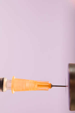 medical syringe cannula with vaccine vial, lilac background. macroの写真素材