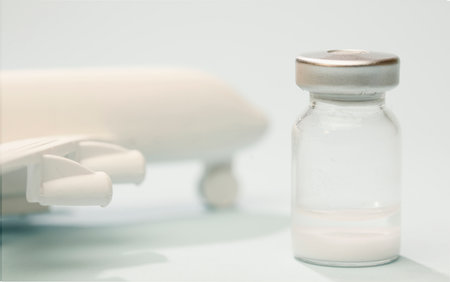 vaccine in glass vial, with white plane, blue background