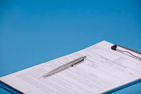 Silver pen on medical report, blue background.