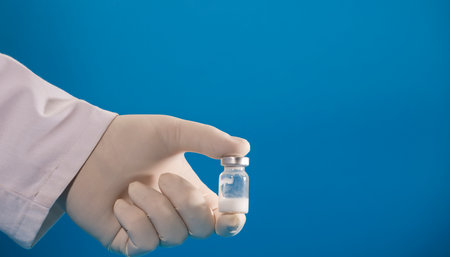 vaccine in the hands of doctor with gloves and blue background