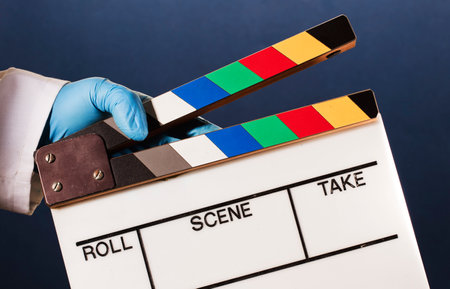 movie clapperboard in doctor hands, blue backgroundの写真素材