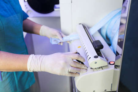 female dentist doctor pack and disinfect medical instrumentsの写真素材