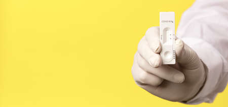 COVID-19 virus disease test in doctor hands, coronavirus crisis test, global pandemic outbreak, deadly SARS-CoV-2 epidemic, test kit illustration, yellow backgroundの写真素材
