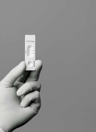 COVID-19 virus disease test in the hands of doctor, coronavirus crisis test, global pandemic outbreak, deadly SARS-CoV-2 epidemic, test kit illustratios, gray backgroundの写真素材