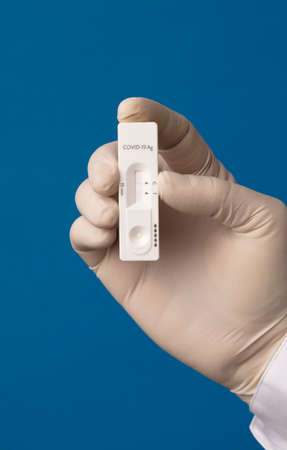 doctor hand with rapid test for coronavirus, blue backgroundの写真素材