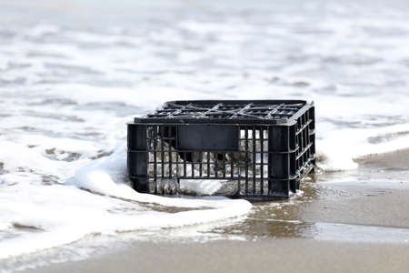 black plastic box thrown on the shore, environmental pollution,の写真素材