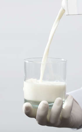 full glass of milk, with gloves, white backgroundの写真素材