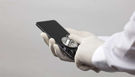 mobile technician, with stethoscope on mobile screen, diagnosis and repair, white backgroundの写真素材