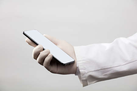 hands with gloves and phone with gray screen, white backgroundの写真素材