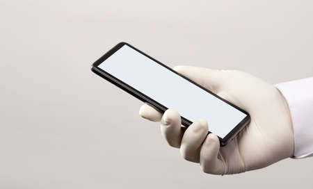 hands with gloves and phone with gray screen, white backgroundの写真素材