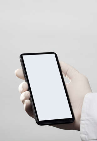 hands with gloves and phone with gray screen, white backgroundの写真素材