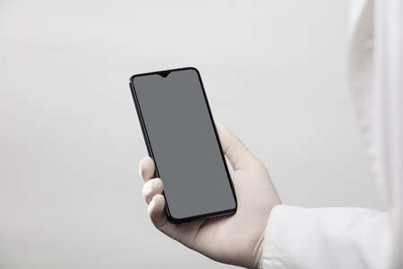 hands with gloves and phone with gray screen, white backgroundの写真素材