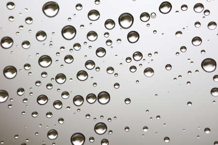 Water drops on white background texture. green background glass covered with water drops. bubbles in the waterの写真素材