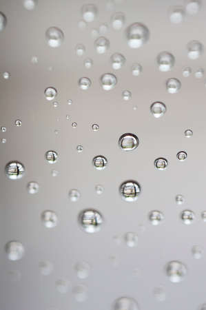 Water drops on white background texture. green background glass covered with water drops. bubbles in the waterの写真素材