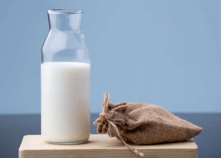 cup of milk with bottle on wood, blue backgroundの写真素材