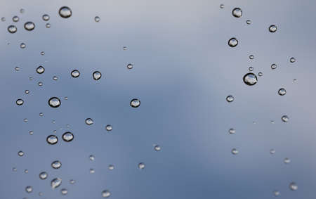 raindrops with sky with clouds, blue grayish blue hueの写真素材