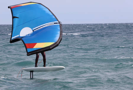 rider on a wind foil board, surf the waves
