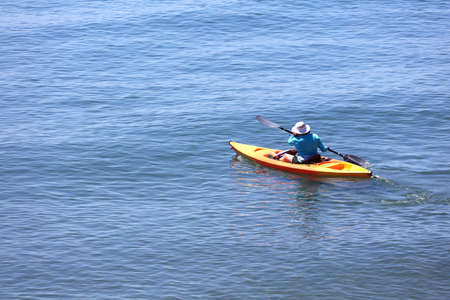 Senior person with kayak sails on the blue seaの写真素材