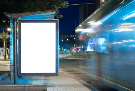 Billboard with light in the city center at night, with bus in motionの写真素材