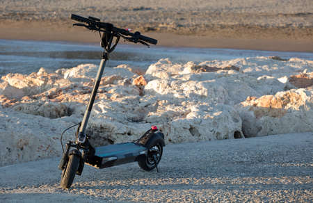 electric scooter near the beach, at sunsetの写真素材