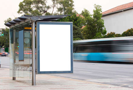 White blank vertical billboard at the bus stop on the city street. In the background of buses and roads. Sketch. Poster on the street next to the roadの写真素材