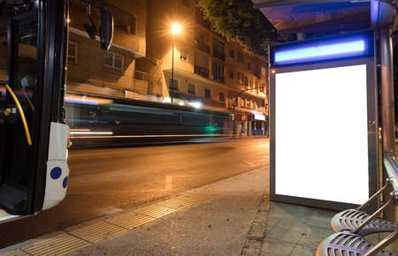 Billboard with light in the city center at night, with 2 bus in motionの写真素材