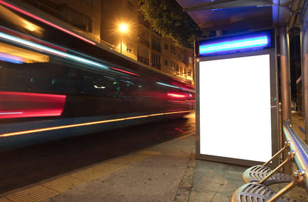 Billboard with light in the city center at night, with bus in motionの写真素材
