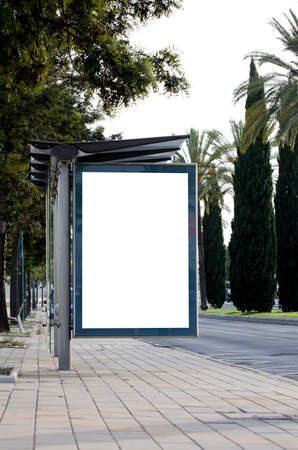 Vertical blank billboard on the city street with green treesの写真素材