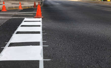 thermoplastic road marking tape, painting traffic lines and bike lanes on asphalt road surface, selective focusの写真素材