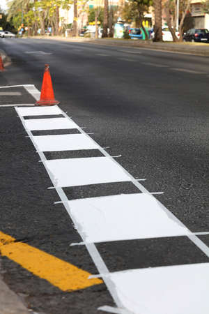 thermoplastic road marking tape, painting traffic lines and bike lanes on asphalt road surface, selective focusの写真素材