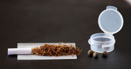 Preparations Hachi cigar, with nozzle, paper, tobacco, plastic container and hashishの写真素材