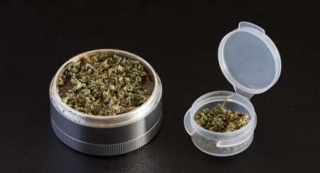 grinder with marijuana and transparent airtight container, black backgroundの写真素材